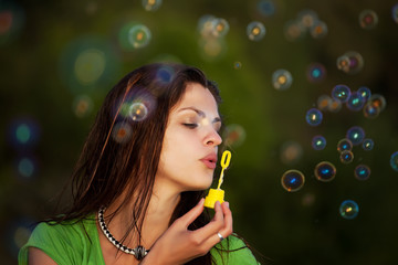 Young girl blowing soap bubbles