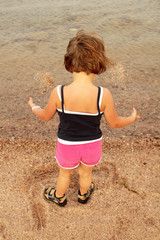 little girl stands on the beach