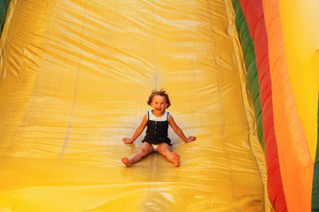 Young girl on the air slide - obrazy, fototapety, plakaty