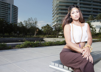 Fototapeta premium Young model sitting on a bench