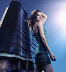 Sexy young beauty posing over night city background