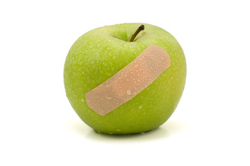green injured apple with plaster,isolated on white background