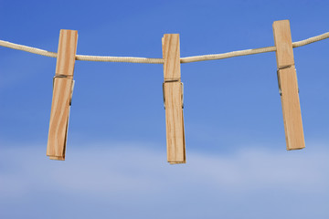 clothesline and pegs on blue sky background