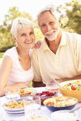 Senior Couple Enjoying Meal In Garden