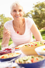 Senior Woman Enjoying Meal In Garden