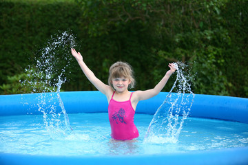 Mädchen im Pool spritzt mit Wasser