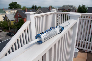 Caulking Gun on Rooftop Deck Railing