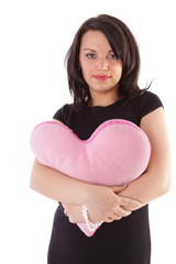 Beautiful young woman with fluffy heart pillow