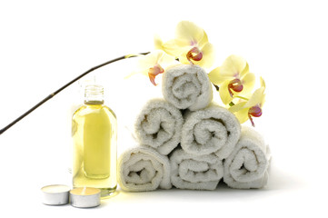 Obraz na płótnie Canvas Spa essentials-roll ręcznik, balsam, świeca i orchidea