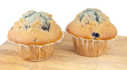 two muffins on chopping block isolated on white