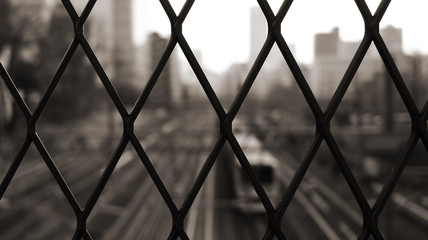 Fototapeta premium A view through a lattice fence and the passing train below.