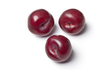 Three whole fresh purple plums