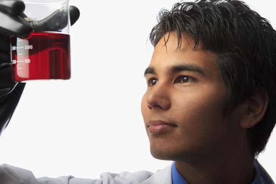 lab technician holding a beaker with fluid inside
