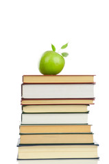 Book heap and an apple isolated on white background.