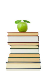 Book heap and apple isolated on white background.