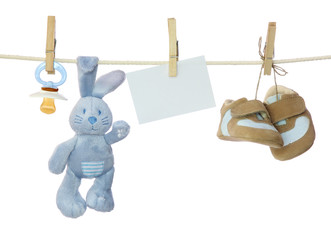 Blue baby goods and blank note hanging on the clothesline