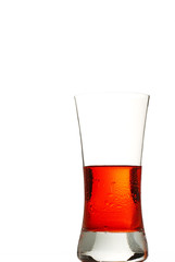 ein kaltes rotes getränk im glas auf weissem hintergrund