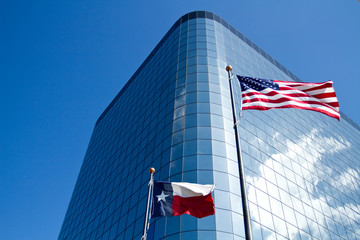 Texas and American flags front of an office building
