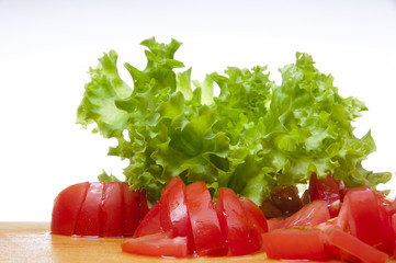 Sliced tomatoes and the fresh lettuce on the board