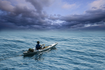 Young man in sea kayak under dramatic skies - 24388432
