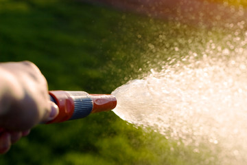 Hand with garden hose
