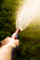 Hand with garden hose