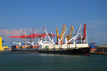 The trading seaport with cranes, cargoes and ship