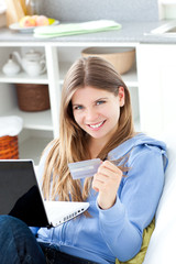 Happy woman with a credit card and a laptop