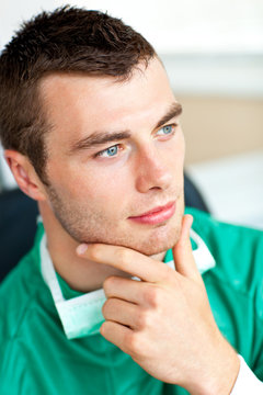 Self-assured male surgeon wearing scrups looking to the side