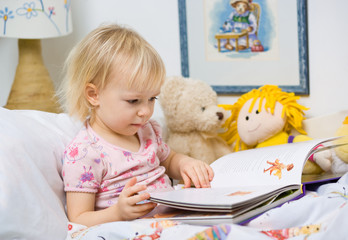 little girl in bed reading book - obrazy, fototapety, plakaty