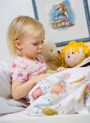 little girl in bed reading book - obrazy, fototapety, plakaty