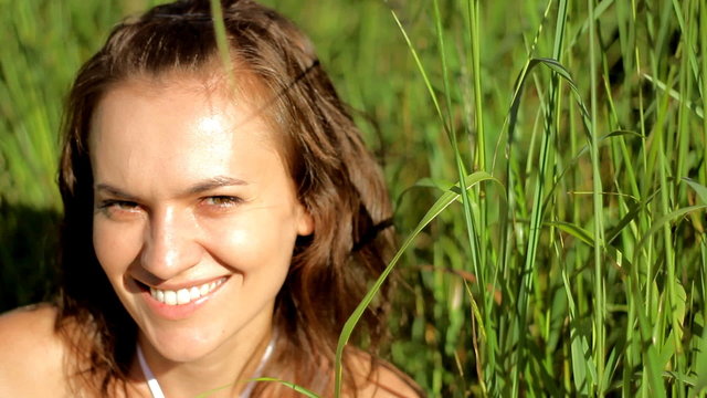 Smiling Woman in grassfields flirting with camera
