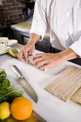Obraz na płótnie Canvas Japanese chef in restaurant making sushi roll