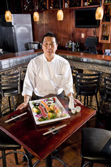 Japanese restaurant chef presenting sushi platter