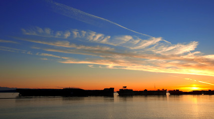 Fototapeta na wymiar Beautiful sunset over moored freighters