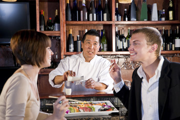 Couple eating sushi in Japanese restaurant