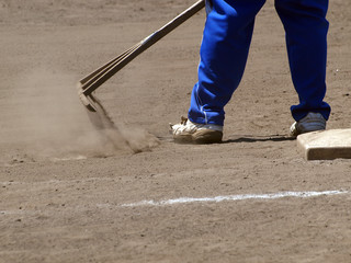 トンボで内野の土を均す整備員