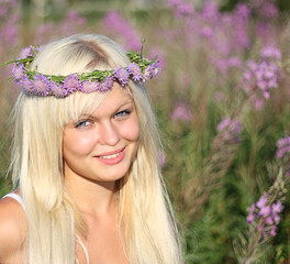 Blond haired blue eyed model in  tall flowers