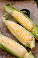 Fresh corn on wooden surface