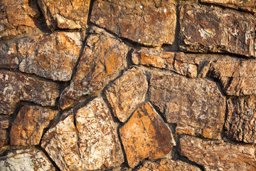Fragment of a stone wall of natural stones background.