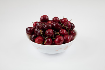 A bowl of fresh cherry isolated on white
