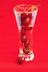 glass of cherry  on a red background