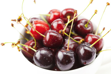 cherry in a cup and saucer isolated on white