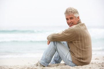 Fototapeta premium Senior Man On Holiday Sitting On Winter Beach