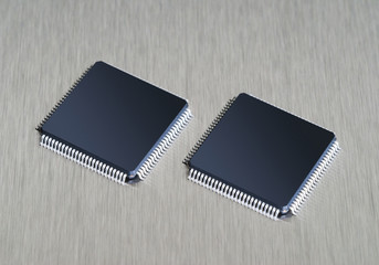 Two computer chips on stainless steel background