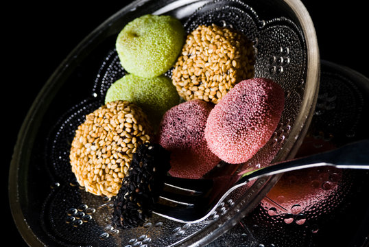Assorted sweets on plate on black background