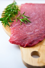 Fresh beef with rosemary on cutting board