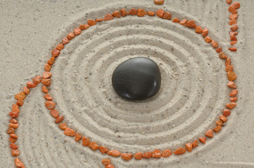Fototapeta na wymiar Black Stone w piasek ze śladami