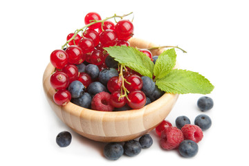 fresh berries in wood bowl isolated