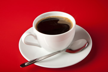 cup of coffee over red background
